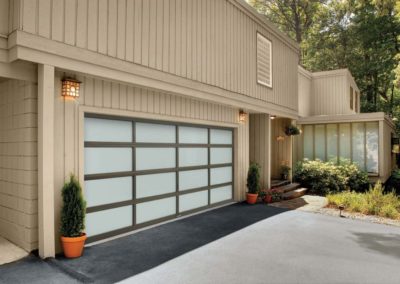 Elegant home with a frosted glass garage door and multiple horizontal panels, providing modern style and privacy