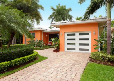 Modern white garage door with horizontal windows on a residential property, ideal for new garage door installation and contemporary home upgrades