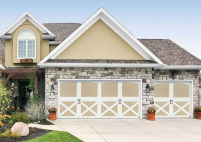 Residential garage door installation featuring a beige and white cross-design double and single door