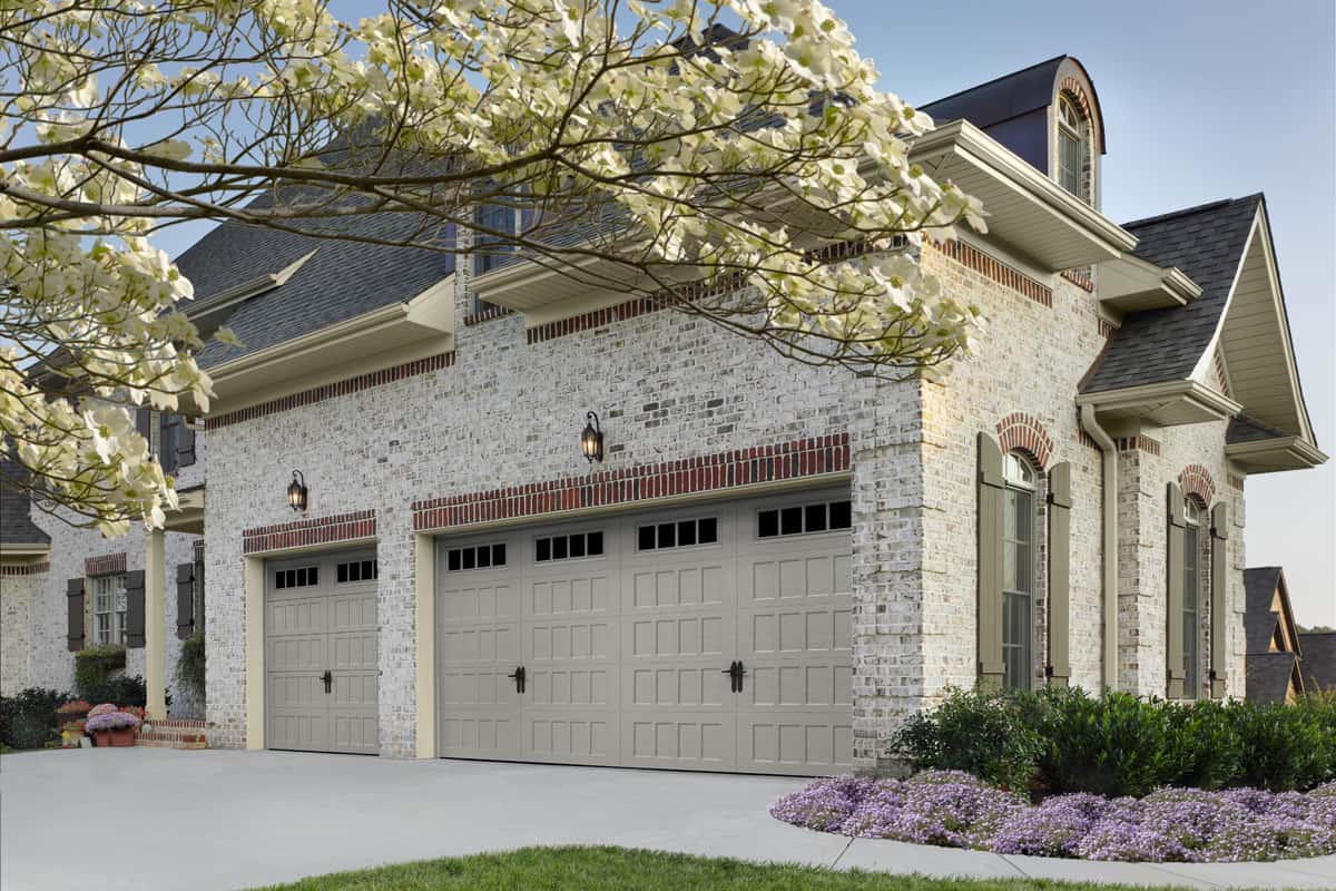 garage-door-with-recessed-panels Gray house with a garage door that has recessed panels